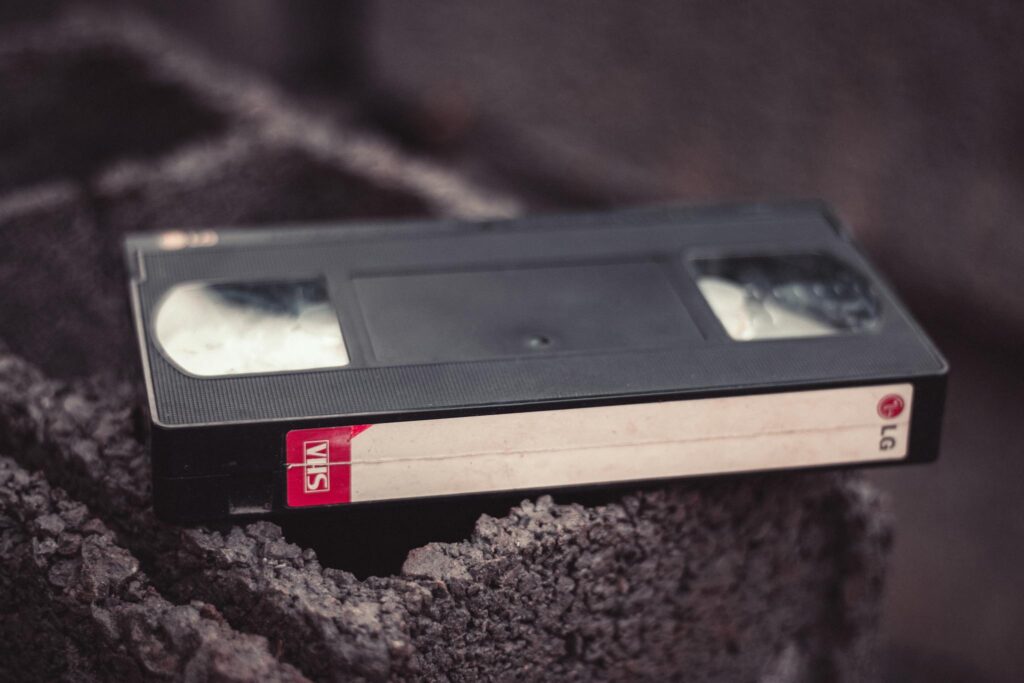 Close-up of a vintage VHS tape resting on a textured surface, offering nostalgic appeal.