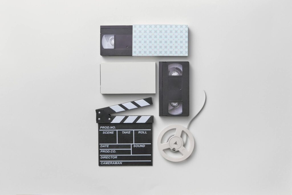 Vintage media setup featuring VHS tapes and a film clapperboard for a nostalgic cinematic feel.